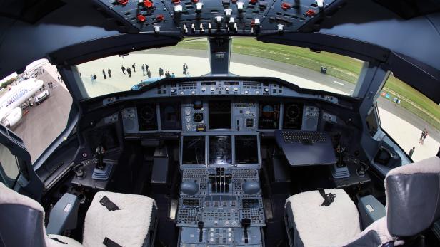 Blick in das Cockpit eines Airbus A380 mit zahlreichen Schaltern und Anzeigen.