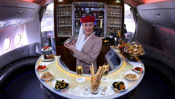 Eine Stewardess mixt Cocktails in der Bar eines Emirates-Flugzeugs.