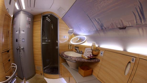Das Badezimmer einer Emirates First Class Suite mit Dusche und Waschbecken.