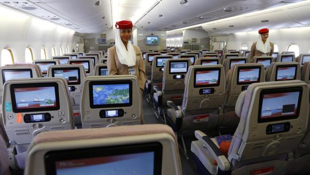 Eine Stewardess steht in der Kabine eines Emirates-Flugzeugs.