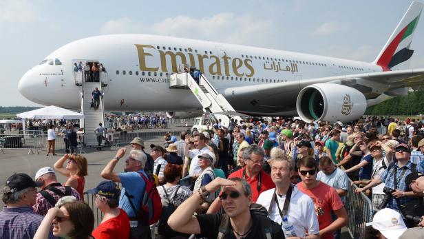Eine Menschenmenge steht vor einem parkenden Emirates Airbus A380.