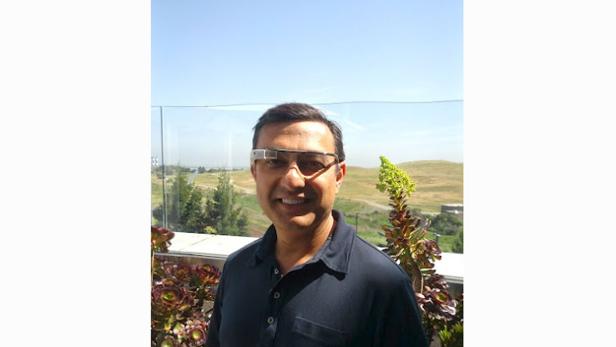 Ein Mann mit Google Glass steht vor einer Landschaft.