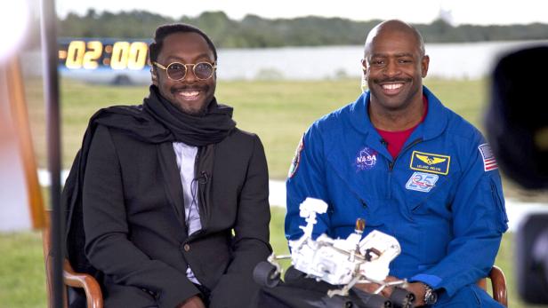 will.i.am (li.) mit NASA-Astronaut Leland Melvin und einem Modell des Mars-Rovers Curiosity.