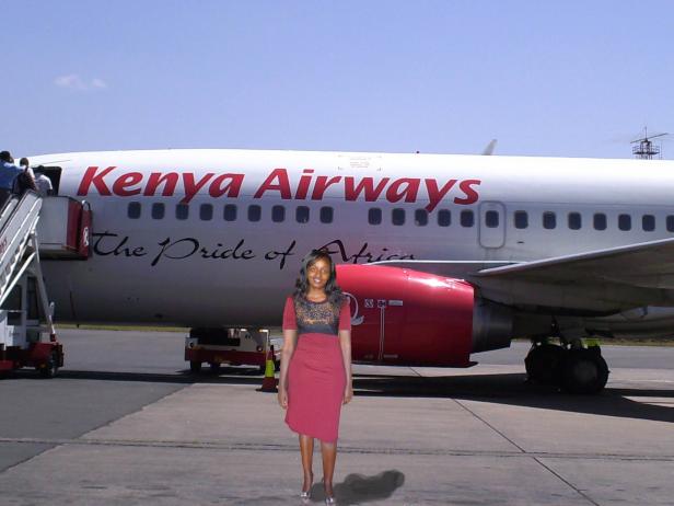 Eine Frau steht vor einem Flugzeug von Kenya Airways.