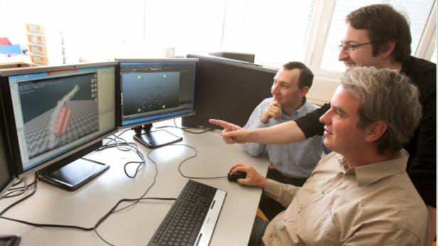 Schordan, Schreiner und Hofmann (von hinten nach vorne) erklären die pysikalische Simulation eines Wasserrades.