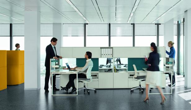 Mehrere Personen arbeiten in einem modernen Großraumbüro.