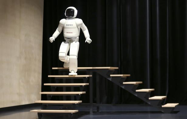Honda's latest version of the Asimo humanoid robot walks down stairs during a presentation in Zaventem near Brussels