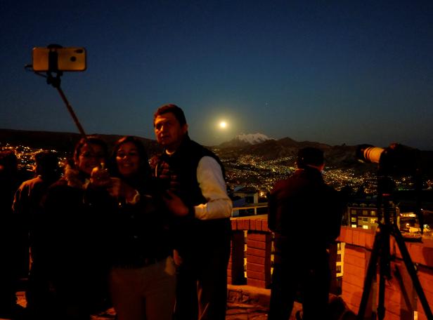 People take a selfie with the moon during a full lunar eclipse in La Paz