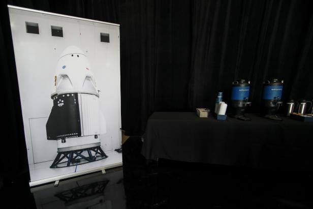 A picture of the Crew Dragon spacecraft is shown next to SpaceX coffee machines at SpaceX headquarters in Hawthorne, California