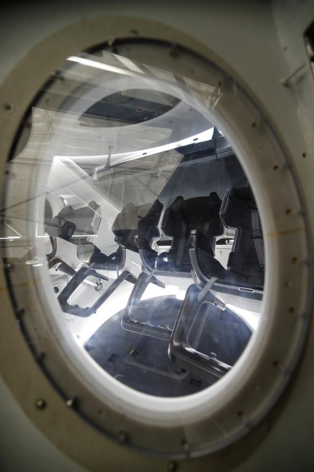 Members of the media gather around a replica of the Crew Dragon spacecraft at SpaceX headquarters in Hawthorne, California