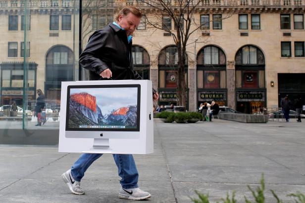 FILE PHOTO: A man carries a newly purchased iMac from the Apple Fifth Avenue store during Black Friday sales in Manhattan, New York, U.S.