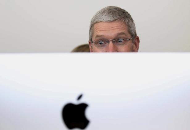 Apple CEO Tim Cook looks at a new IMac after presentation at Apple headquarters in Cupertino