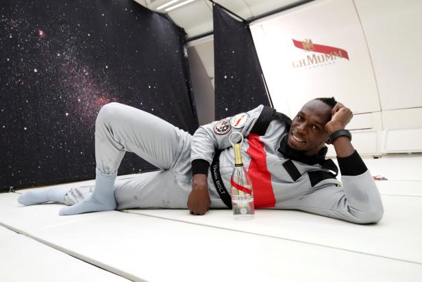 Retired sprinter Usain Bolt poses with a bottle of "Mumm Grand Cordon Stellar" champagne as he enjoys zero gravity conditions during a flight in a specially modified Airbus Zero-G plane above Reims