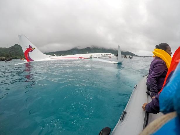 Handout photo of U.S. Navy Sailors assisting local authorities in shuttling passengers and crew of Air Niugini flight PX56 to shore following the plane crashing into the sea on its approach to Chuuk International Airport in Weno, Chuuk, Micronesia