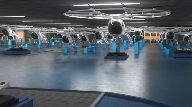 Eine Halle mit vielen weißen, unbemannten Flugtaxis auf blauen Podesten.