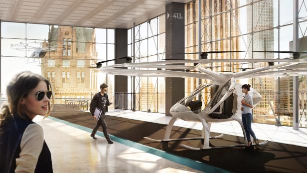 In einer futuristischen Station steht ein senkrecht startendes Flugtaxi, während Menschen vorbeigehen.