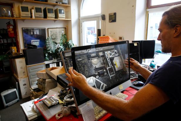 Der österreichische Computersammler Borsky justiert den Bildschirm eines iMac in seinem Büro in Wien.