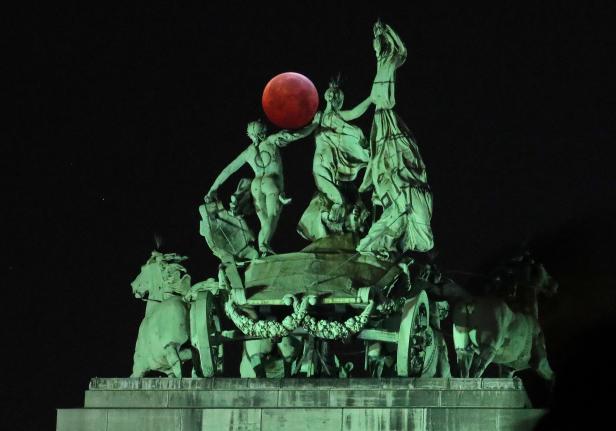 The moon is seen beside a quadriga on the top of the Cinquantenaire arch during a total lunar eclipse known as the "Super Blood Wolf Moon", in Brussels