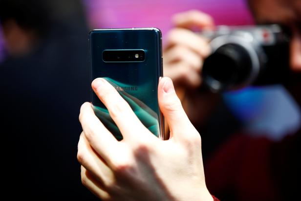 A journalist photographs the new Samsung Galaxy S10e smartphone at a press event in London