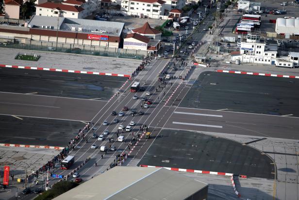 Pedestrians and drivers cross the tarmac at Gibraltar International Airport near the border with Spain in the British overseas territory of Gibraltar, historically claimed by Spain