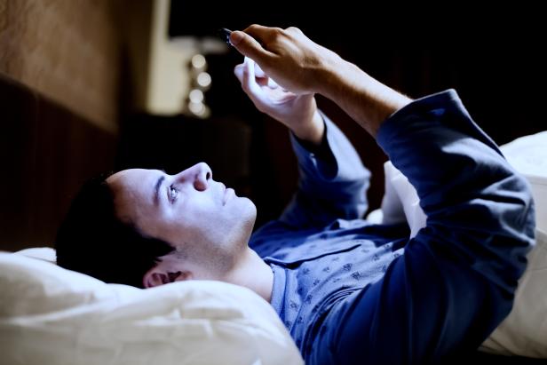 Man using his phone in the bed