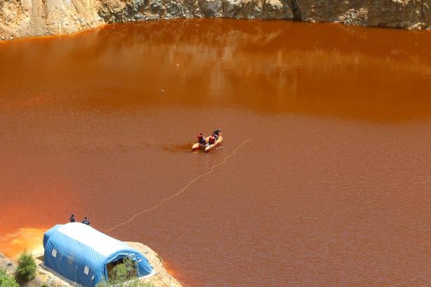 Forensics officers search Kokkinopezoula lake, also known as "red lake", for possible bodies of victims of a suspected serial killer near the village of Mitsero