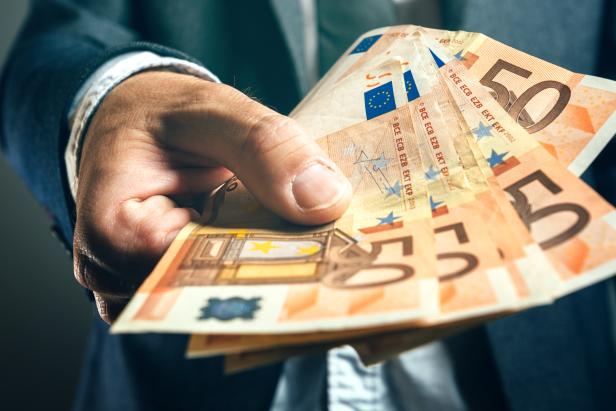 Businessman from bank offering money loan in euro banknotes