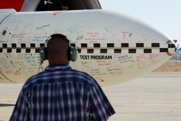 A rocket scribbled with notes from Virgin Orbit staff sits underneath the wing of a modified Boeing 747 jetliner prior to takeoff of a key drop test of its high-altitude launch system for satellites from Mojave, California