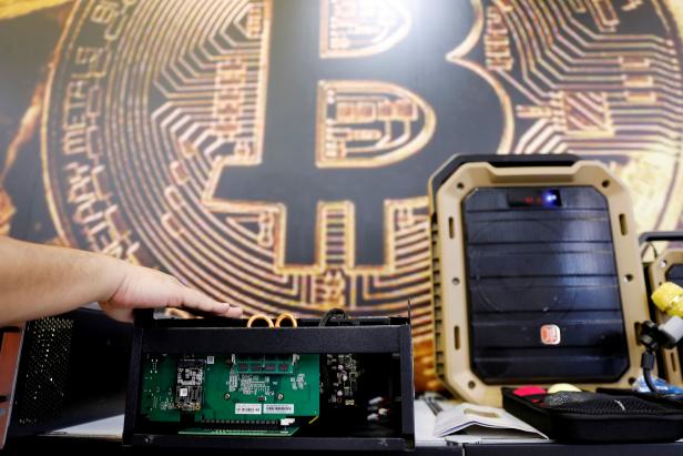 FILE PHOTO: A cryptocurrency mining computer is seen in front of bitcoin logo during the annual Computex computer exhibition in Taipei