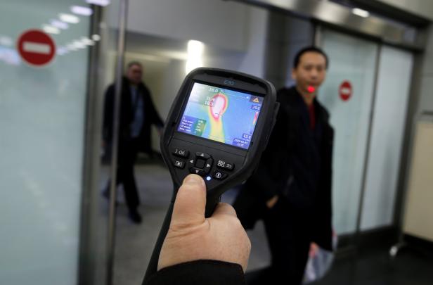 Kazakh sanitary-epidemiological service worker uses a thermal scanner to detect travellers from China who may have symptoms possibly connected with the previously unknown coronavirus, at Almaty International Airport