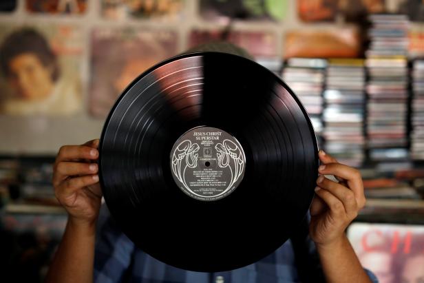 A man shows a vinyl record at "El Pollo Musical" (The Musical Chicken) record store in San Salvador