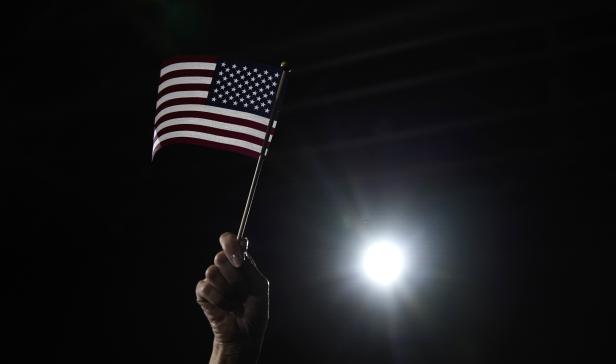 A supporter waves a U.S. flag as Democratic presidential candidate and former South Bend, Indiana Mayor Pete Buttigieg speaks at his rally at Drake University in Des Moines, Iowa, U.S.