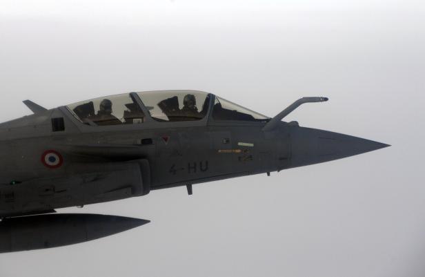 A French Rafale fighter jet demonstrates the interception of a Belgian air force transport plane as they fly over France