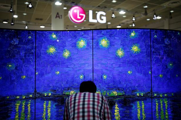 A man examins LG Electronics' double-faced and curved OLED TV during Korea Electronics Show 2016 in Seoul