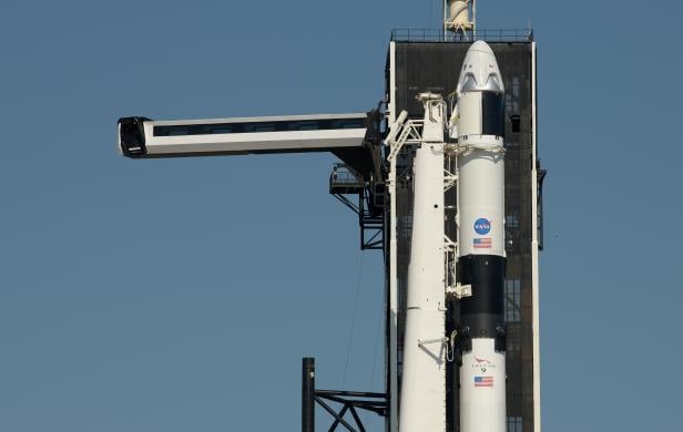 FILE PHOTO: The crew access arm is swung into position to a SpaceX Falcon 9 rocket with the company's Crew Dragon spacecraft onboard