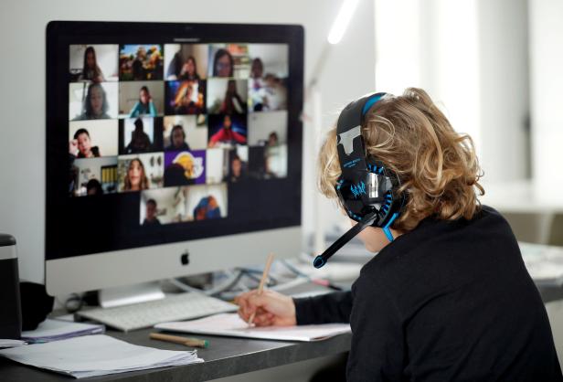 FILE PHOTO: A student takes classes online with his companions using the Zoom APP at home