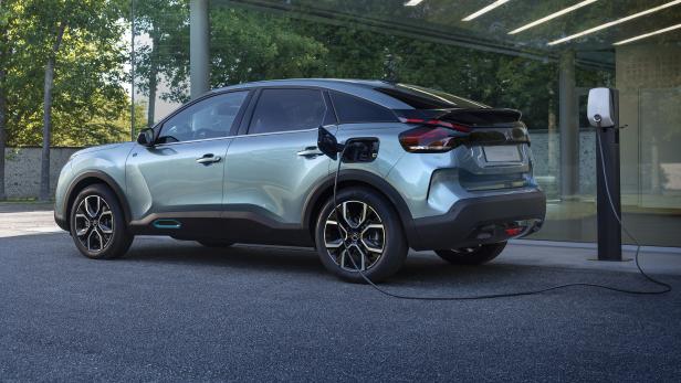 Ein hellblauer Citroën ë-C4 wird an einer Ladestation aufgeladen.