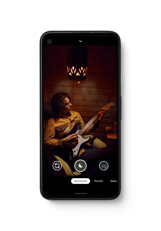 Ein Mann mit Gitarre, aufgenommen mit dem Nachtsichtmodus eines Smartphones.