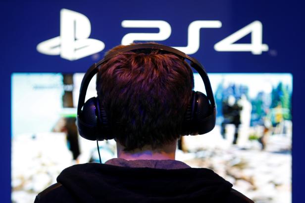 A visitor plays games on PlayStation 4 (PS4) at the Paris Games Week, a trade fair for video games in Paris