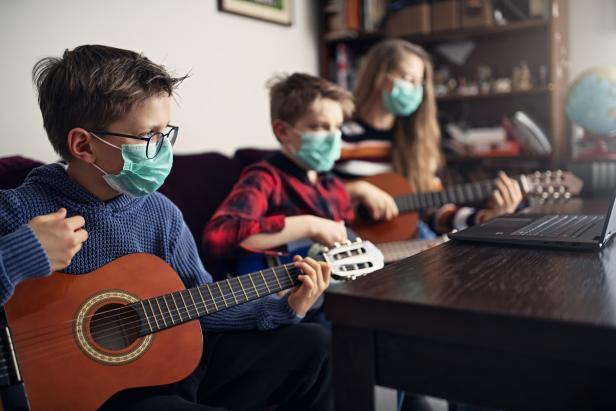 Brother and sister playing guitars together