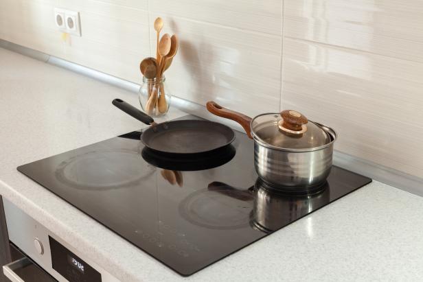 Wooden spoons in modern kitchen with induction stove