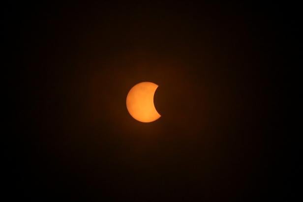 A solar eclipse is pictured during a cloudy day, in Villarrica