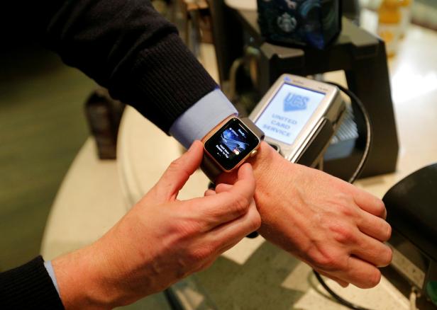 FILE PHOTO: Man uses Apple Watch to demonstrate mobile payment service Apple Pay at cafe in Moscow