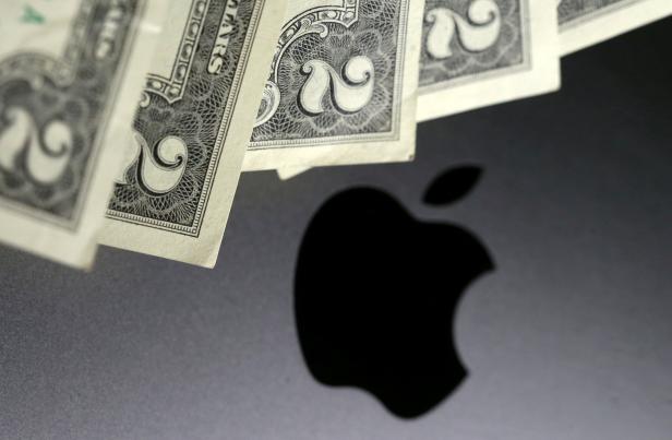 FILE PHOTO: Photo illustration of U.S. dollar banknotes in front of the Apple logo
