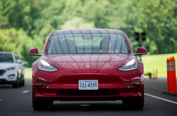 IIHS media relations associate Young demonstrates front crash prevention test on Tesla Model 3 at IIHS-HLDI Vehicle Research Center in Ruckersville, Virginia