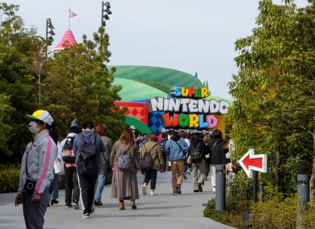 Visitors walk toward to Super Nintendo World at the Universal Studios Japan theme park in Osaka, Japan