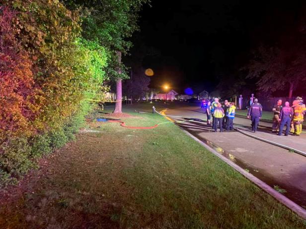 Emergency services personnel stand near the site of a Tesla vehicle crash in The Woodlands, Texas