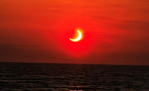 Partial solar eclipse is seen above the horizon in Avon-by-the-Sea