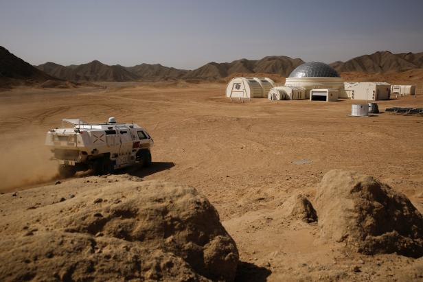 An electric 4WD vehicle designed to represent a vehicle used for an imagined Mars exploration drives near the C-Space Project Mars simulation base in the Gobi Desert outside Jinchang