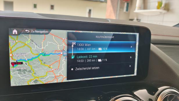 Das Navigationssystem eines Autos zeigt eine Route von Innsbruck nach Wien mit einer Ladezeit von 22 Minuten an.